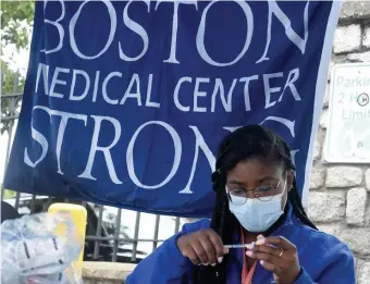  ?? BOstOn HeraLd FILe ?? TAKE A SHOT: Boston Medical Center nurse Eunide Guillet prepares a dose of coronaviru­s vaccine at a recent event in Mattapan.