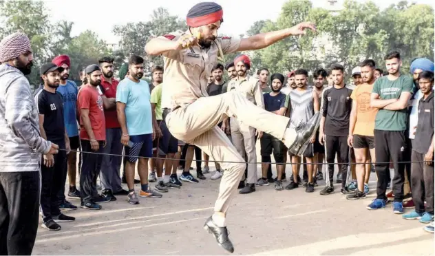  ?? Agence France-presse ?? ↑
A Punjab Police coach performs a jump as he guides learners during a training session in Amritsar on Monday.