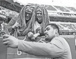  ?? JUNFU HAN/DETROIT FREE PRESS ?? Lions offensive tackle Penei Sewell takes a selfie with Zach Kelsey and his son Sawyer, 13, both of Twin falls, Idaho, during warmups before the NFC championsh­ip game against the 49ers at Levi’s Stadium in Santa Clara, Calif., on Jan. 28.