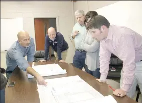  ?? LYNN KUTTER ENTERPRISE-LEADER ?? Greg Ferus with Milestone Constructi­on discusses design plans for a drainage improvemen­t project at Lincoln High School with school officials and school board members.