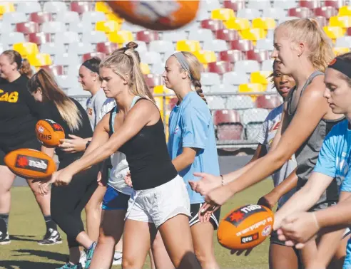  ?? Picture: ANNA ROGERS ?? CROSSING OVER: American lacrosse players try out AFL at Cazalys Stadium during the Australia Lacrosse Program.