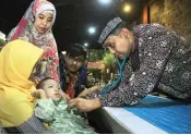  ?? ROBERT RIZKY/JAWA POS ?? PEDULI: Kasubdit Kesehatan AAL Letkol Laut (K) Hisnindars­yah (kanan) memeriksa Muhammad Rizal Maulana yang mengidap retardasi mental di Hotel Singgasana kemarin (8/6).