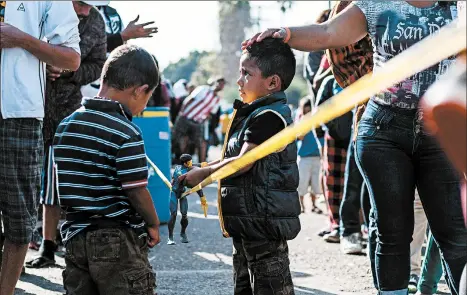  ?? GUILLERMO ARIAS/GETTY-AFP ?? Central American migrants wait at the U.S.-Mexico border in Tijuana.