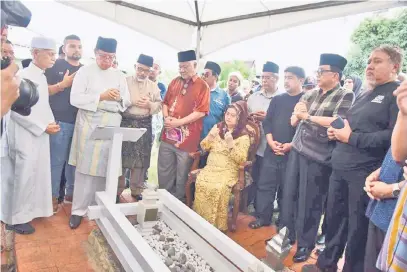  ??  ?? SEMOGA DIRAHMATI: Abang Johari (dua kiri) bersama ahli keluarga yang lain menyedekah­kan bacaan surah Al-Fatihah dan doa di pusara Abang Abdul Ghafor.