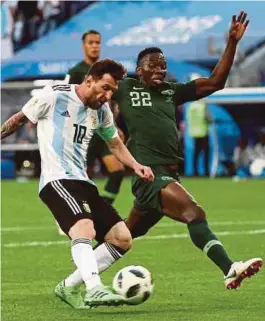  ?? [ FOTO REUTERS ] ?? Messi (kiri) menjaringk­an gol pertama Argentina pada perlawanan menentang Nigeria, kelmarin.