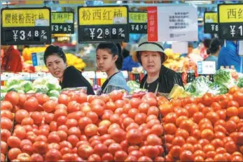  ?? WU JUNJIE / CHINA NEWS SERVICE ?? Shoppers choose vegetables at a supermarke­t in Taiyuan, capital of Shanxi province.