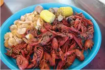  ??  ?? n Boiled and seasoned crawfish are served with corn on the cob and shrimp. The Whitlow brothers say their secret is the eight-and-a-half-hour drive Wednesday to a huge crawfish farm in Mamou, a town in Louisiana’s Evangeline Parish, near the Gulf...