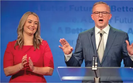  ?? (AFP) ?? Australian Opposition Leader Anthony Albanese (right), accompanie­d by his partner Jodie Haydon, addresses Labour supporters at the Federal Labour Reception in Sydney on Saturday