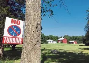  ??  ?? Loud and clear: A sign opposing a turbine project in north smithfield. — AP