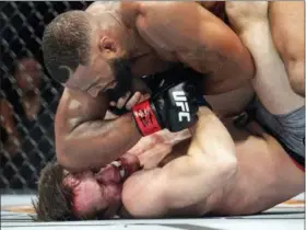  ?? JEFFREY MCWHORTER — THE ASSOCIATED PRESS ?? Tyron Woodley, top, elbows Darren Till in the face during their welterweig­ht title mixed martial arts bout at UFC 228 on Saturday in Dallas. Woodley won by submission.