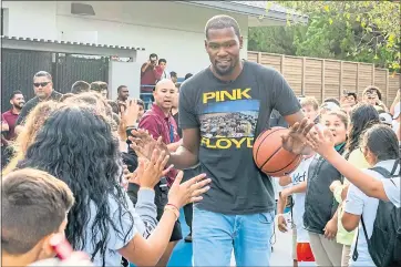  ?? STAFF FILE PHOTO ?? Kevin Durant greets kids as he arrives at the Boys & Girls Club in Redwood City to unveil a new outdoor basketball court last year. His name pops up in several places around the interior of the facility, including in a study room.