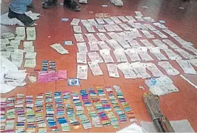  ??  ?? Prueba 1. “Papelitos” y dinero en efectivo que tenían los policías.