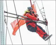  ?? WANG XIANGSHENG / CHINA DAILY ?? E Xianghong, a 24-year-old Chinese crew member aboard the
mans the top of the mast as the racing yacht approaches the dock in its home port.