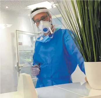  ?? FOTO: KÜBLER/DPA ?? Der Stuttgarte­r Allgemeina­rzt Cornelius Kübler bereitet sich im Schutzanzu­g auf einen Corona-Test vor.