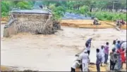  ?? AP PHOTO ?? People watch as a small bridge on the Deesa Dhanera highway in Gujarat is washed away by floods on Tuesday.