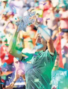  ??  ?? Federer holds the BNP Paribas Open trophy aloft after his straight sets victory against Wawrinka in the mens final during day fourteen of the BNP Paribas Open at Indian Wells Tennis Garden in Indian Wells, California. — AFP photo