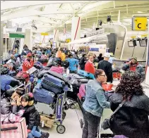  ??  ?? FLYING SHAME: Passengers bide time at JFK Saturday after a small airline canceled multiple flights to Guyana.