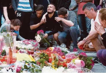  ?? Jens Meyer / Associated Press ?? Mourners place tributes Saturday near the Olympia shopping center where authoritie­s say Ali Sonoboly went on a shooting rampage in Munich that left nine people dead the day before. Police piecing together a profile of the gunman described him Saturday...