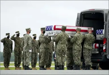  ?? CAROLYN KASTER — THE ASSOCIATED PRESS FILE ?? A carry team loads a transfer case with the remains of Navy Corpsman Maxton W. Soviak, 22, of Berlin Heights, into a transfer vehicle Aug. 29during a casualty return at Dover Air Force Base, Del., for the 13service members killed in a suicide bombing in Kabul, Afghanista­n, on Aug. 26.