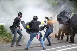  ?? ALEX MILAN TRACY — THE ASSOCIATED PRESS FILE ?? Members of the far-right group Proud Boys and anti-fascist protesters spray bear mace at each other during clashes in Portland, Ore., on Aug. 22, 2021.