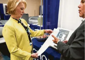  ?? Brett Coomer / Staff photograph­er ?? Harris County Clerk Diane Trautman, left, checks out a voting machine demonstrat­ed by Bryan Hoffman at a trade show Tuesday in Houston.