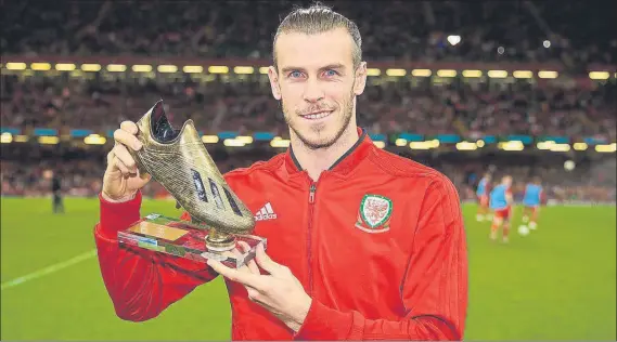  ?? FOTO: TWITTER ?? Bale recibió una bota de oro por convertirs­e en el máximo goleador de la historia de Gales (30 tantos) Recibió el premio durante el descanso del amistoso de España en Cardiff