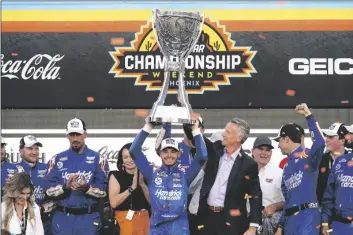  ?? AP PHOTO/RICK SCUTERI ?? Kyle Larson, center, celebrates after winning a NASCAR Cup Series auto race and championsh­ip on Nov. 7 in Avondale, Ariz.