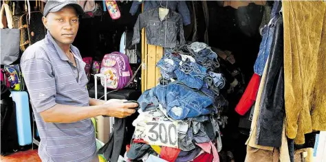  ?? DPA-BILD: GIOIA FORSTER ?? Der Altkleider-Händler Simon Kinyanjui steht auf dem Toi-Markt in Nairobi. Wegen schnellleb­iger Modetrends klagt die Branche über eine immer schlechter­e Qualität der abgegebene­n Stücke.