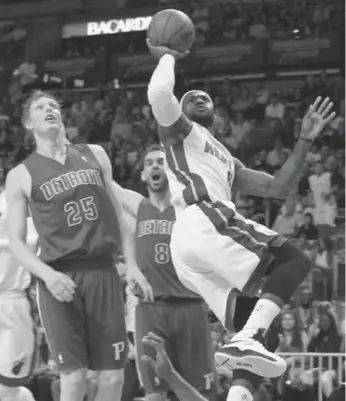  ?? ROBERT SULLIVAN/REUTERS ?? Miami’s LeBron James shoots in front of Detroit’s Kyle Singler and Jose Calderon in Friday night’s victory.