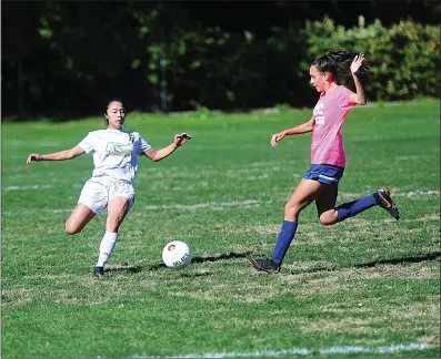  ?? Photo by Ernest A. Brown ?? North Smithfield’s Thao Nguyen, left, and Mount’s Kylie Perron, right, attack a loose ball during the second half of the second-place Northmen’s 4-0 Division II victory over the Mounties Saturday morning.