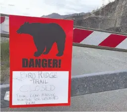  ?? AP Photo/Mark Thiessen ?? A sign warns people that the trail head is closed Monday after a fatal bear mauling Sunday at Bird Ridge Trail in Anchorage, Alaska. Authoritie­s say a black bear killed a 16-year-old runner while he was competing in a race.