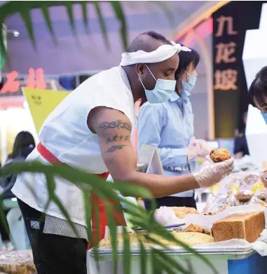  ??  ?? On October 16, 2020, at the 2020 Chongqing Internatio­nal Culture and Tourism Industry Expo, a young man from Ethiopia speaking fluent Chinese sells various products made in a poverty-alleviatio­n workshop in the Fuling Red Wine Town.
