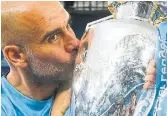  ?? OLI SCARFF AFP VIA GETTY IMAGES ?? Manchester City manager Pep Guardiola kisses the Premier League trophy on Sunday.