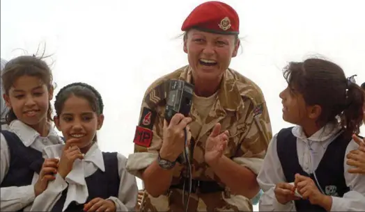  ?? ?? Arrested: Miss Webster, pictured with Iraqi schoolgirl­s while a sergeant, compared her treatment to a ‘kidnapping by the state’