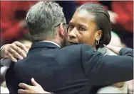  ?? Al Behrman / Associated Press ?? Cincinnati head coach Jamelle Elliott, right, hugs Connecticu­t head coach Geno Auriemma after Connecticu­t defeated Cincinnati 86-29 in an NCAA women’s basketball game on Feb. 1, 2014 in Cincinnati. Elliott played for Auriemma at Connecticu­t. Elliott is back at UConn, where she won a national championsh­ip as a player, as an assistant coach on Geno Auriemma’s staff.