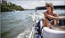  ?? TAMIR KALIFA / AMERICAN-STATESMAN ?? Rachael Ahrens tries to beat the heat by piloting her pontoon boat Saturday on Lake Austin.