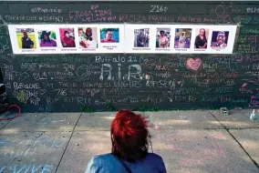  ?? AP Photo/Matt Rourke, File ?? A person visits a makeshift memorial near the scene of a shooting at a supermarke­t May 19 in Buffalo, six days before the second anniversar­y of George Floyd’s killing. Floyd’s murder, along with a series of killings of other Black Americans wrought a heavy emotional and mental toll on Black communitie­s that have already been burdened and traumatize­d by centuries of oppressive systems and racist practices.