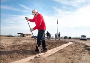  ?? VINCENT OSUNA PHOTO ?? Jesus Amial brushes dirt to clean a sidewalk during during Saturday’s tree-planting ceremony at Memory Gardens Cemetery.