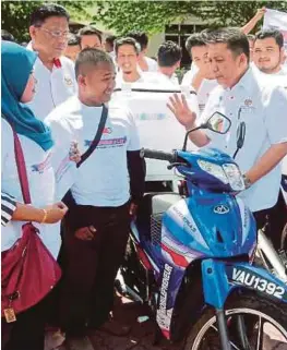  ?? [FOTOFARISZ­AINULDIN/BH] ?? Ahmad Jazlan (kanan) berbual dengan usahawan yang menerima motosikal pada Majlis Penyerahan Mobilepren­eur peringkat Kelantan di Pusat Transforma­si Ilmu, Machang, semalam.