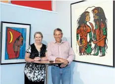  ?? LAURA BARTON/POSTMEDIA NEWS ?? Susan Ward, member of the Welland Museum board of directors, stands with its president Greg D'Amico between two paintings that are a part of the upcoming Our Voices exhibit. The paintings were done by Norval Morrisseau, a Anishinaab­e artist, and are...