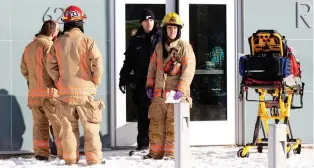  ?? ALLEN McINNIS ?? Police and firefighte­rs wait outside Riverside Pool, where children evacuated from Ecole des Decouvreur­s wait on Monday.