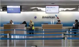  ?? Photograph: Mary Altaffer/AP ?? American Airlines employees wait for passengers to check in at LaGuardia airport in New York city.