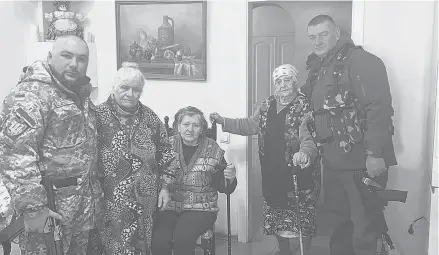  ?? ALEXANDER DEMICH ?? Maria Stasenko, second from right, stands next to her grandson, preparing to fight with Ukrainian forces.