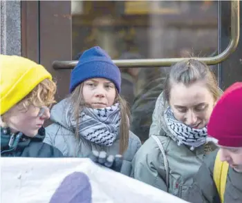  ?? — AFP ?? Swedish climate activist Greta Thunberg (second left) and a group of fellow activists block the main entrances of the Swedish Parliament during a protest due to the lack of action from the Swedish authoritie­s, on Monday, in Stockholm, Sweden.