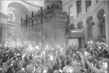  ?? DAN BALILTY/ASSOCIATED PRESS ?? Christians hold candles at the church of the Holy Sepulcher, traditiona­lly believed to be the burial site of Jesus Christ, during the ceremony of the holy fire in Jerusalem’s Old City on Saturday. The “holy fire” was passed among worshipper­s outside the Church and then taken to the Church of the Nativity in the West Bank town of Bethlehem, where tradition holds Jesus was born.