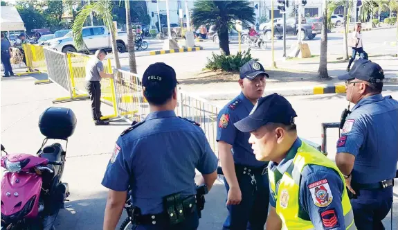  ?? (NEF LUCZON) ?? CAGAYAN DE ORO police officers begin putting up security barricades and assume at their station as the Black Nazarene procession begins January 8 in the evening.