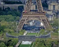  ?? AURELIEN MORISSARD/THE ASSOCIATED PRESS ?? Stands are under constructi­on Monday on the Champ-de-Mars near the Eiffel Tower in Paris. The Champ-de-Mars will host beach volleyball and blind football at the Paris 2024 Olympic and Paralympic Games. The Games begin in late July.