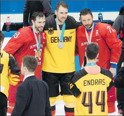  ?? GETTY IMAGES ?? A member of the German hockey team poses for a photo with Russian stars Pavel Datsyuk (left) and Ilya Kovalchuk on the final day of the Olympics. The OAR rallied to win the gold-medal game 4-3 in overtime.