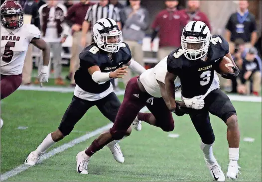  ?? / Jeremy Stewart ?? Rockmart’s Zabrion Whatley (3) is tackled by Heard County’s Komari Clark as teammate Javin Whatley (6) runs to the play during the fourth quarter of the GHSA Class AA state football championsh­ip game Wednesday at Mercedes-Benz Stadium in Atlanta.