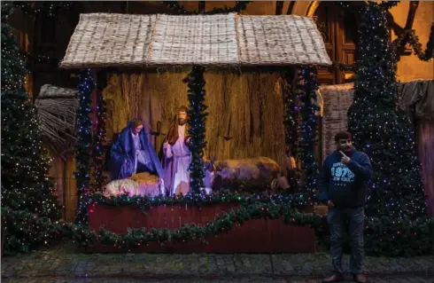  ??  ?? Top, a man poses in front of a nativity scene at a church on Dec. 19. With all that has gone on in the United States, is the greatest threat to Christiani­ty in America from American Christians?